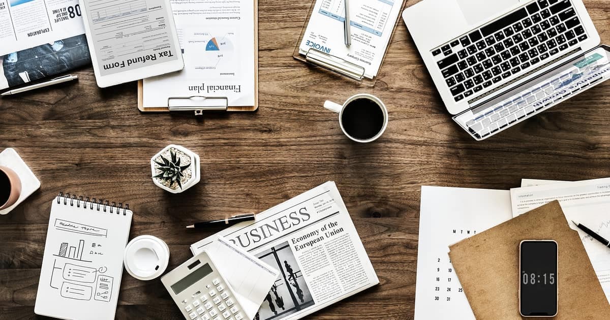 Modern workspace with laptop, notebook and coffee, representing AI tools that help small business owners save time in 2026